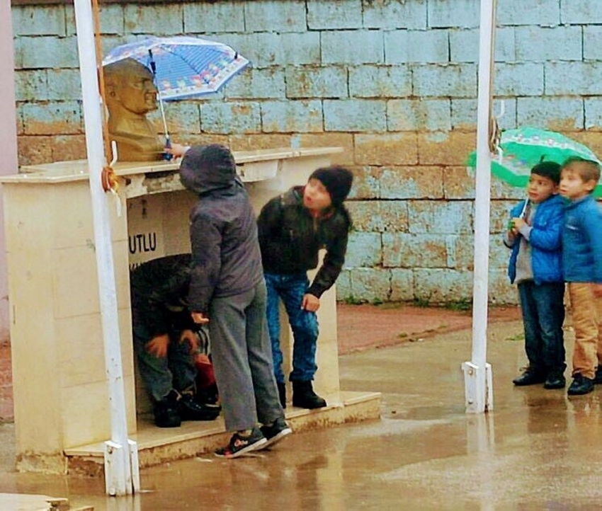 Minik öğrenciler Atatürk büstü ıslanmasın diye şemsiye tuttular