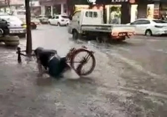 Yağmurlu havada vatandaş bisikletiyle suya battı